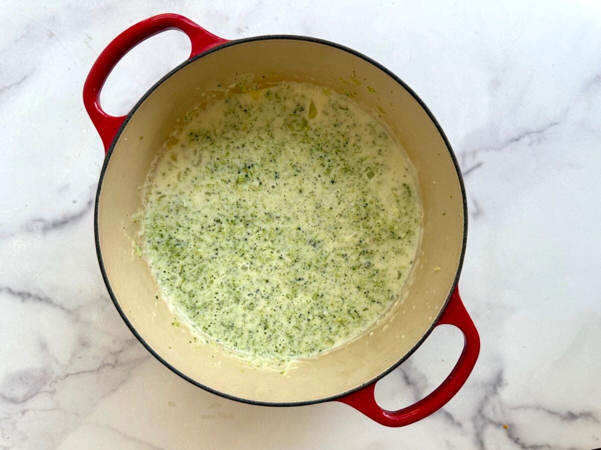 Creamy broccoli soup in a red enameled cast iron pot.