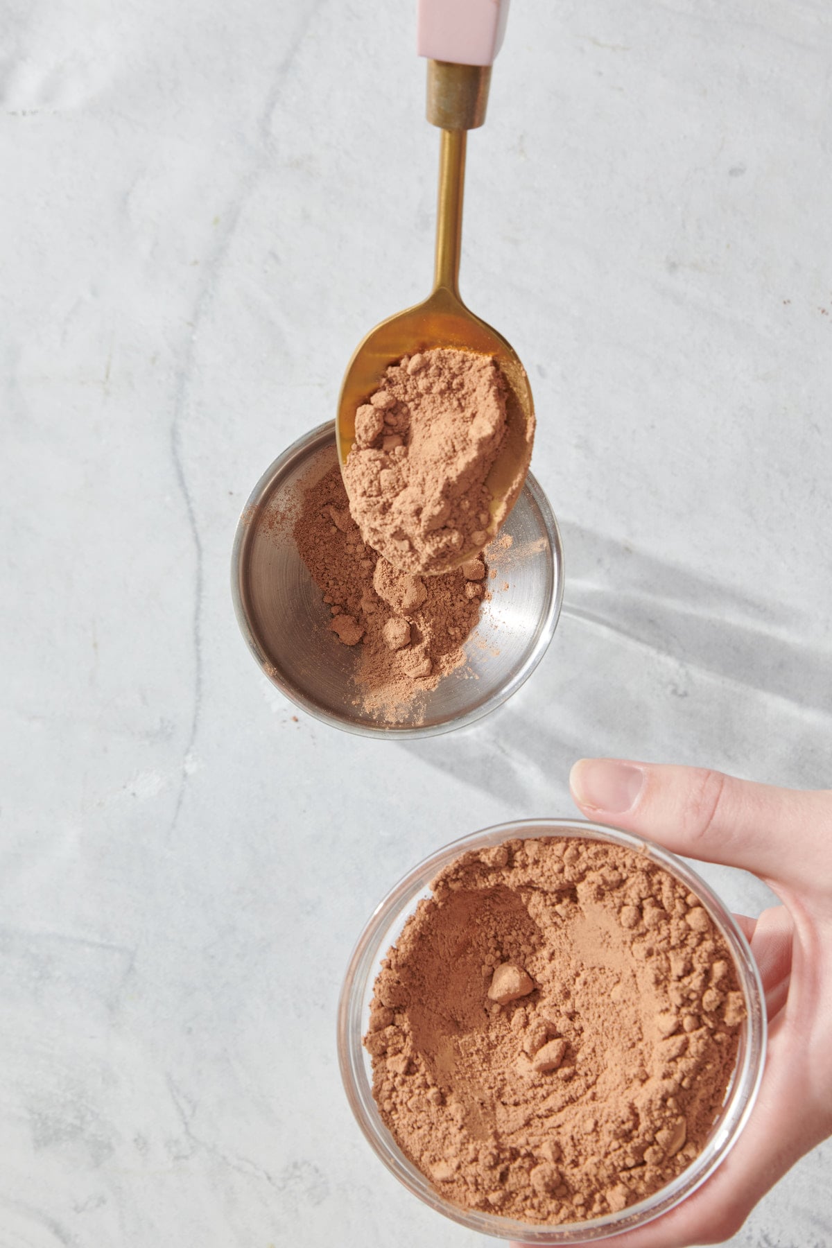 Funneling cocoa powder into a mason jar.