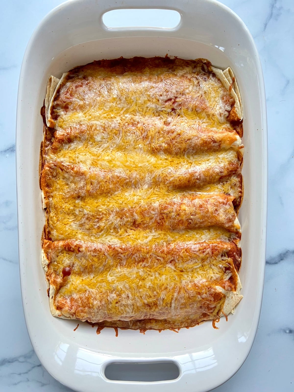 Sweet potato black bean enchiladas in baking dish.