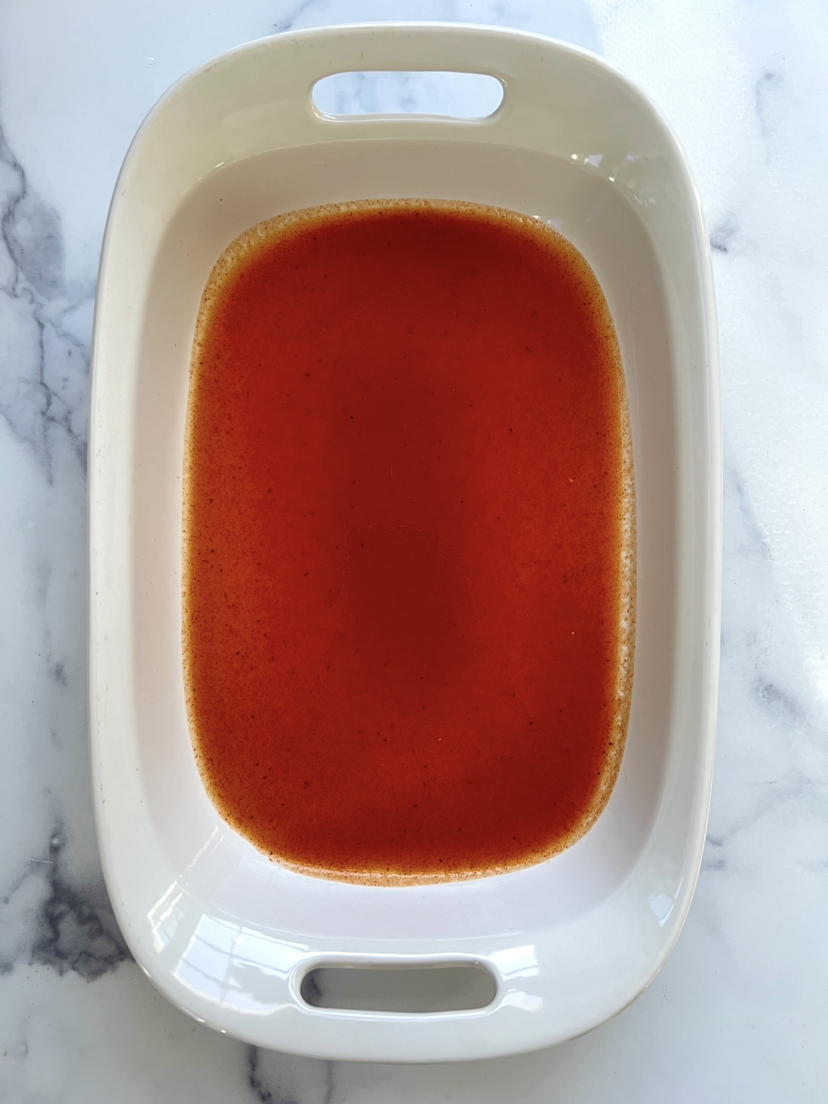 Enchilada sauce in a baking dish.