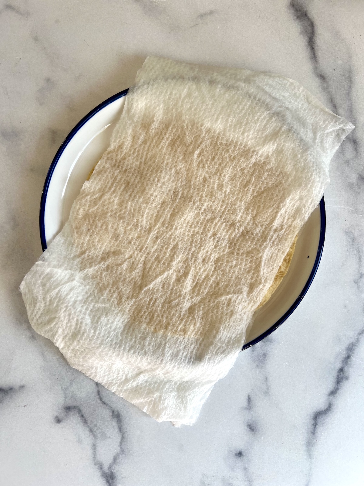 Corn tortillas with wet paper towel on top ready to be microwaved.
