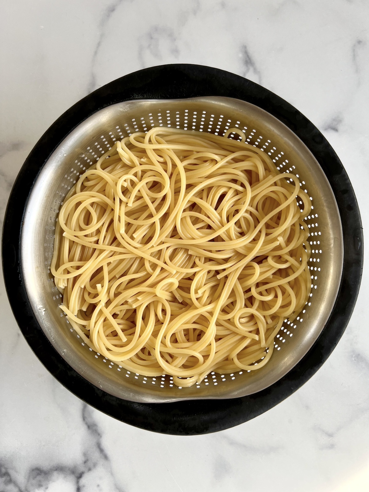 Cooked spaghetti in a colander.