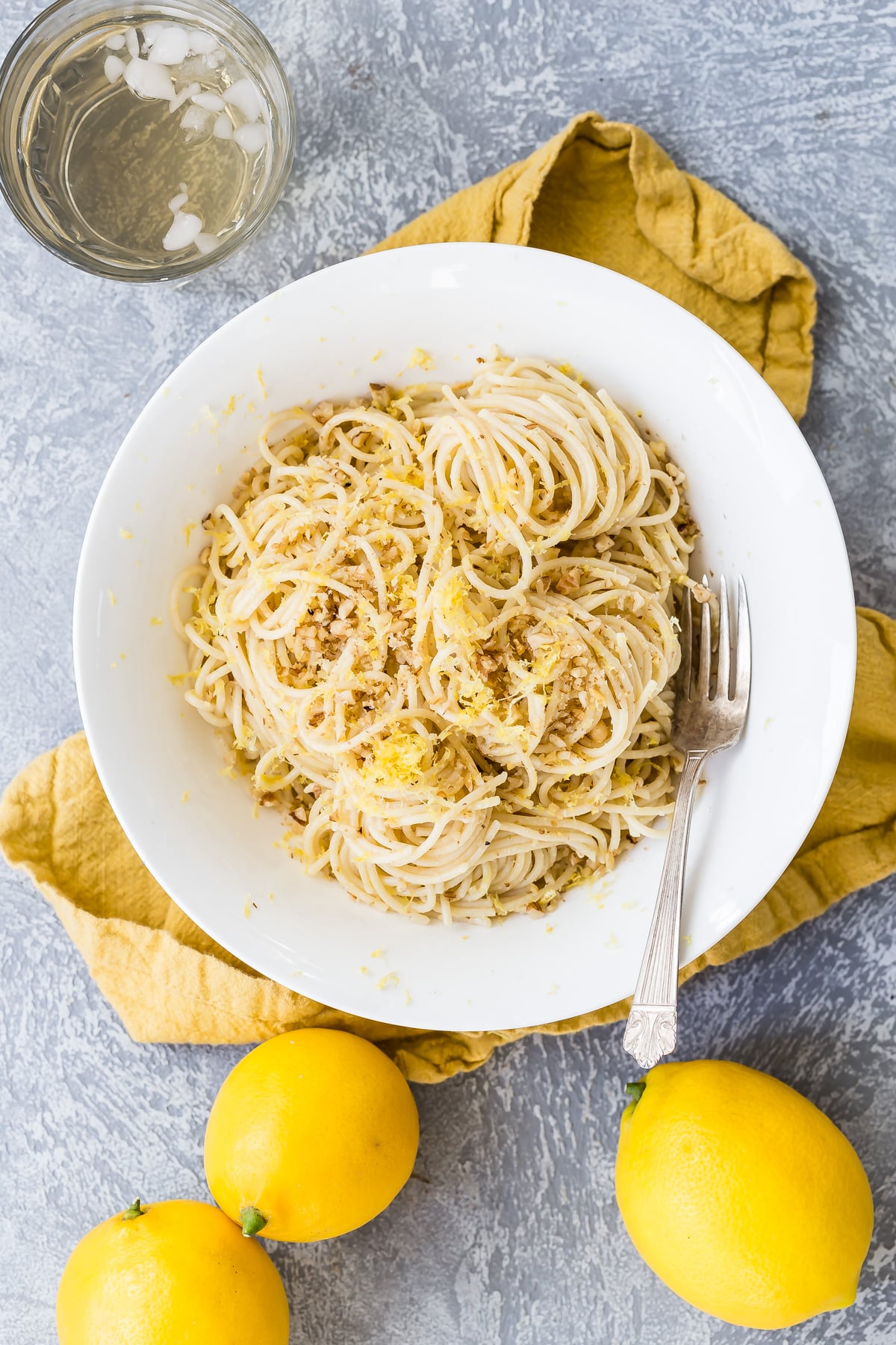 Lemon spaghetti with toasted walnuts in serving platter.