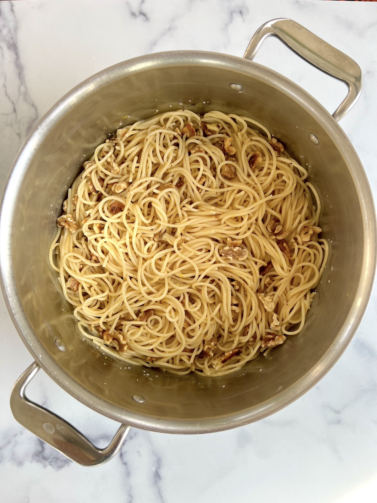 Lemon spaghetti with toasted walnuts in a pot.