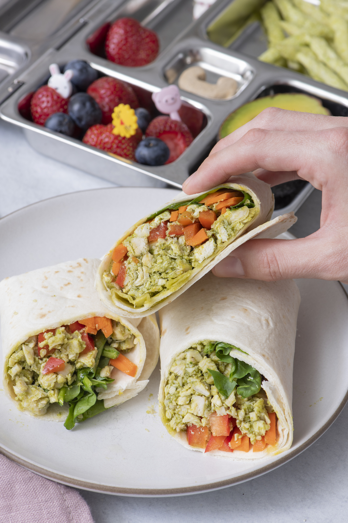 Hand holding chicken pesto wrap.