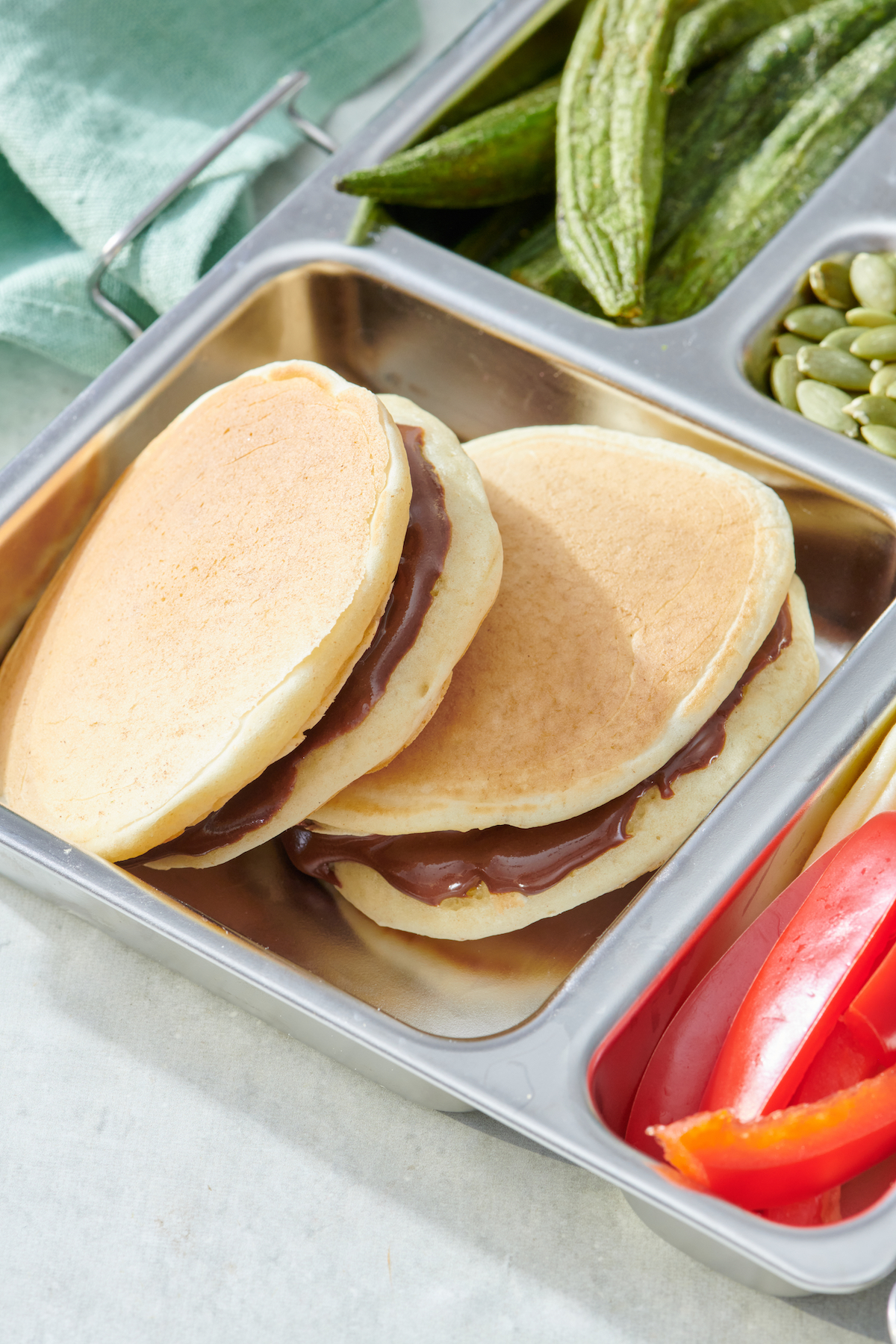 Chocolate sunbutter pancake sandwiches in a lunch box.