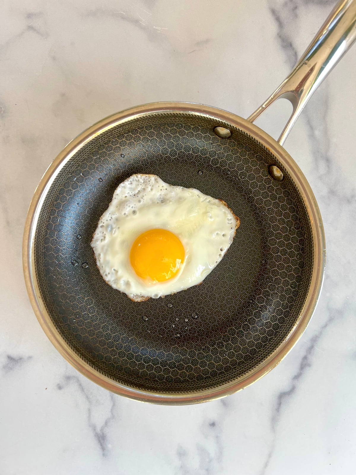 Crispy fried egg in a pan.