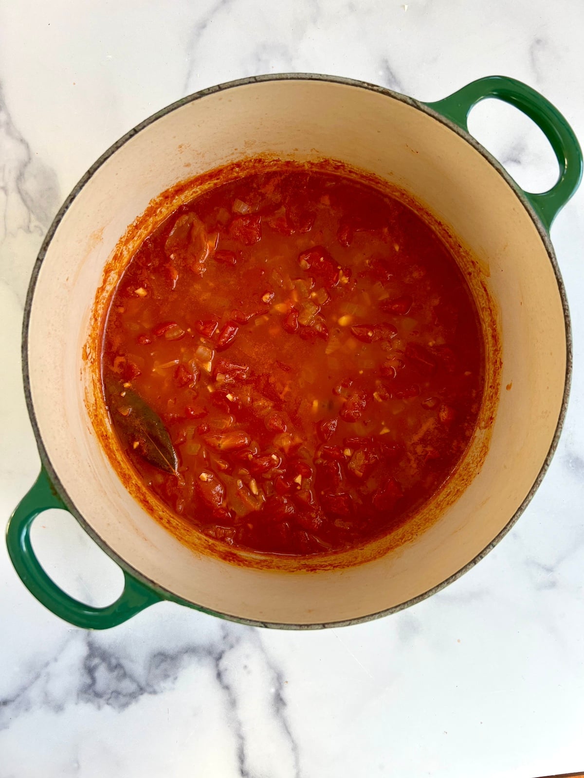 Seafood stew base simmering in pot.