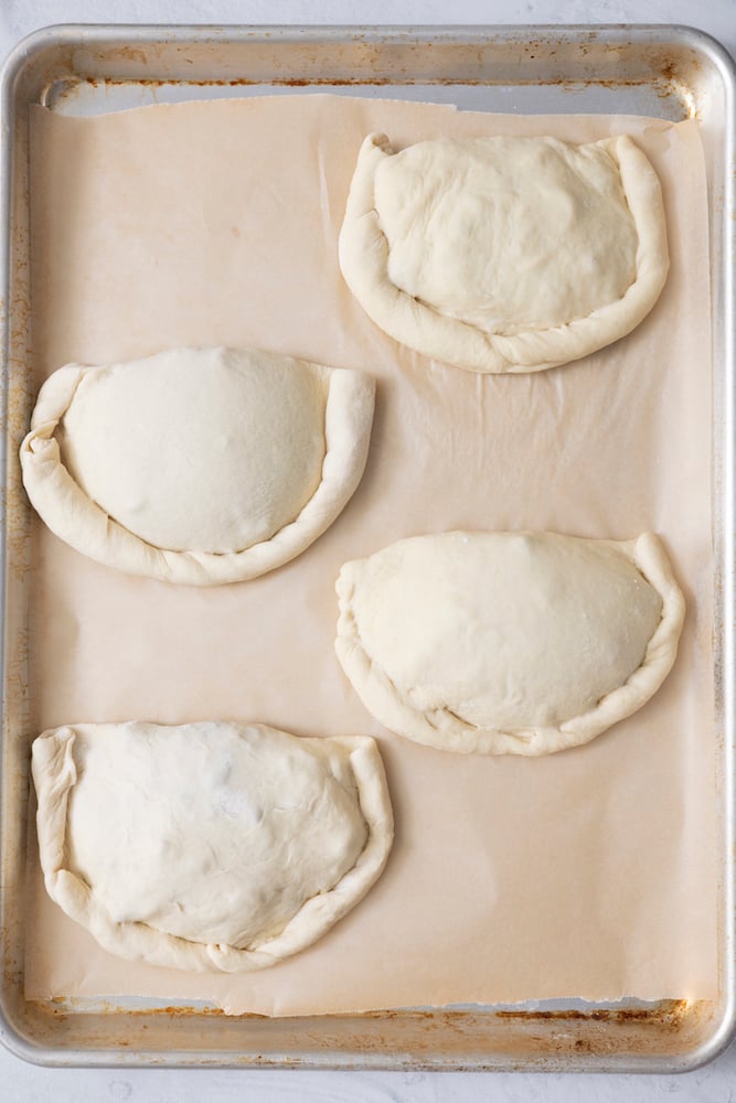 Uncooked Vegetarian Calzones on baking sheet.