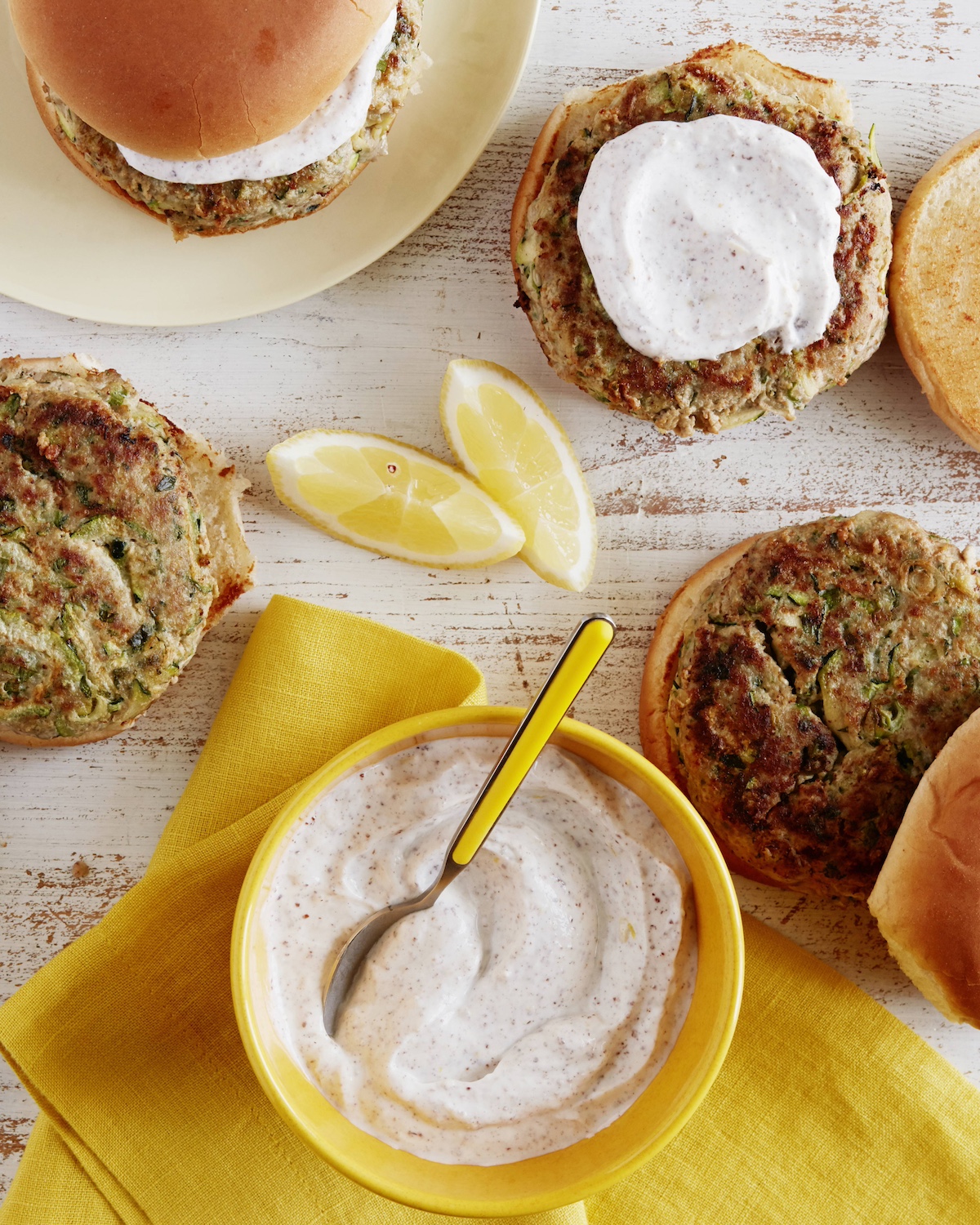 Turkey zucchini burgers on buns served with yogurt sumac sauce.