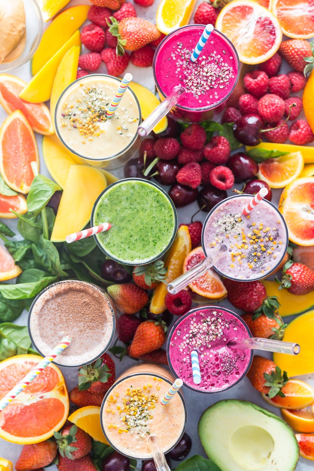 Smoothies surrounded by fresh fruit.