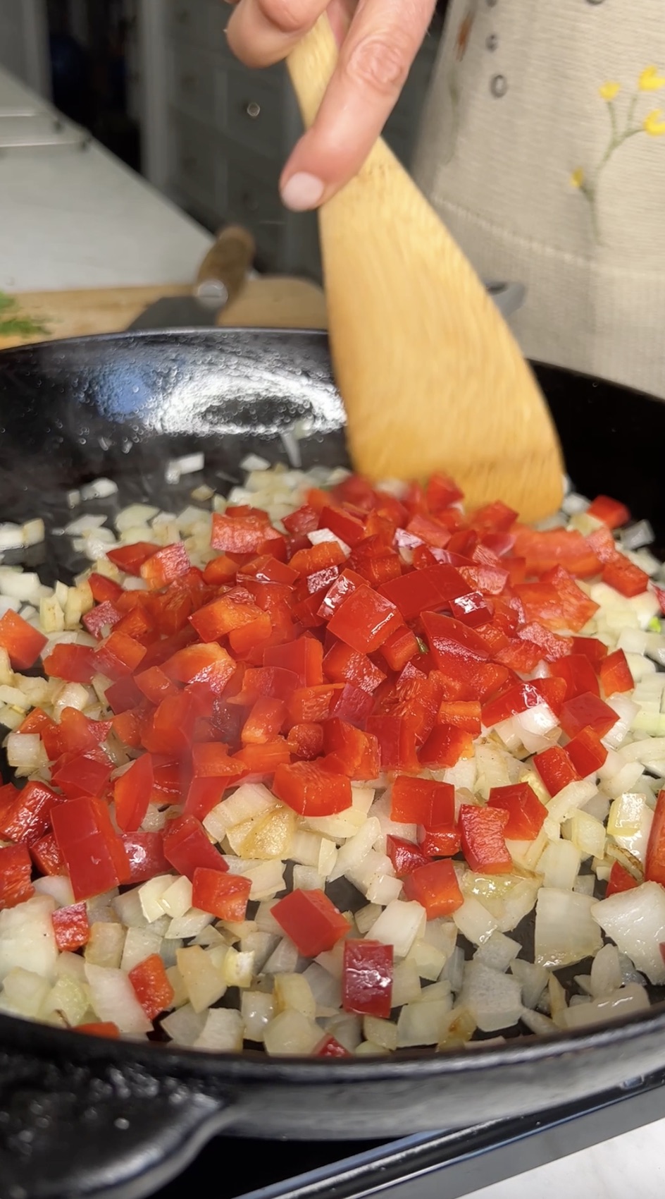 Bell pepper and onion sauteeing in skillet.