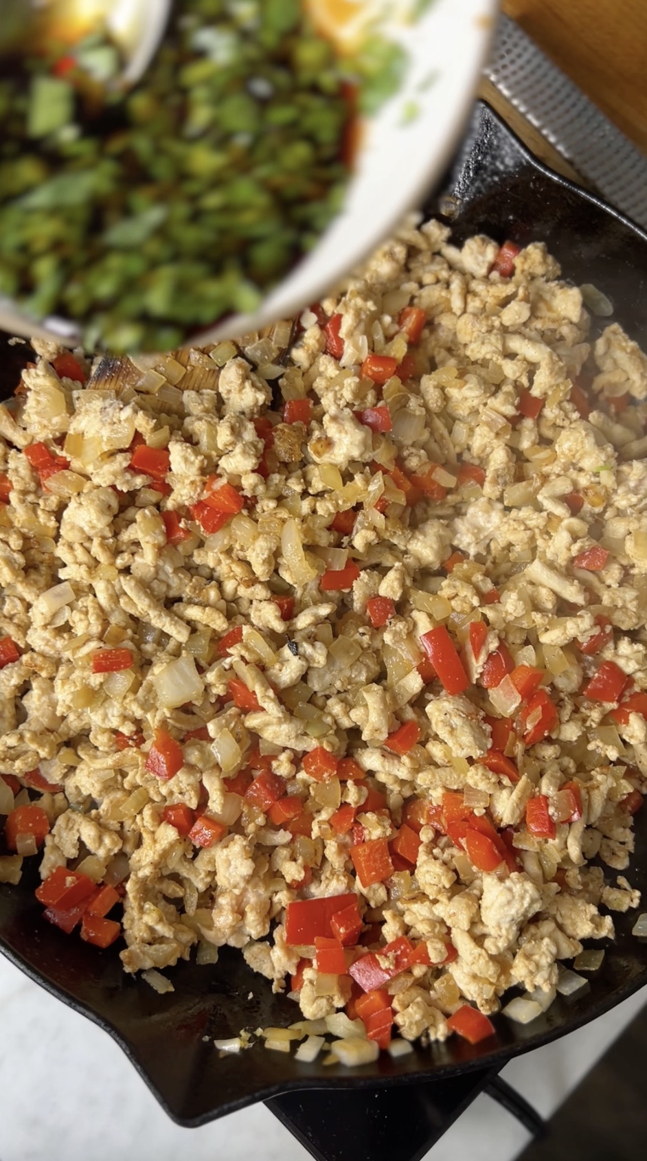 Ground chicken sauteeing with vegetables.
