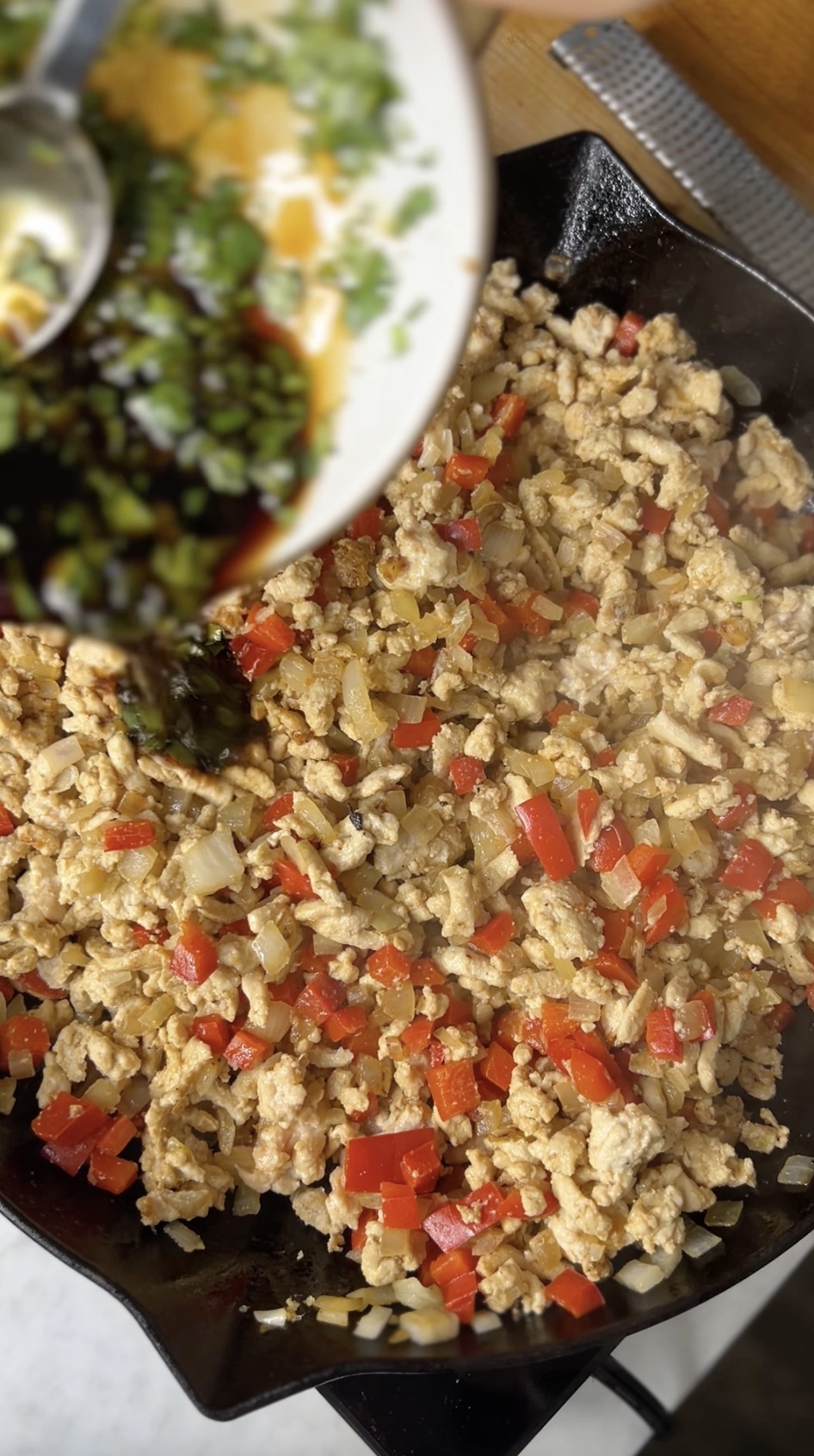 Adding stir-fry sauce to ground chicken mixture.