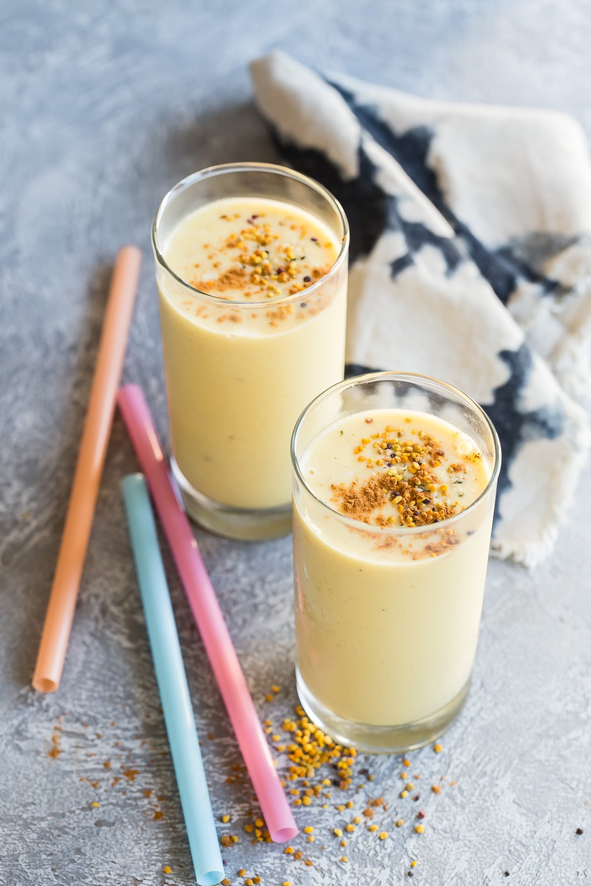 Mango Spiced Smoothie in glasses topped with bee pollen.