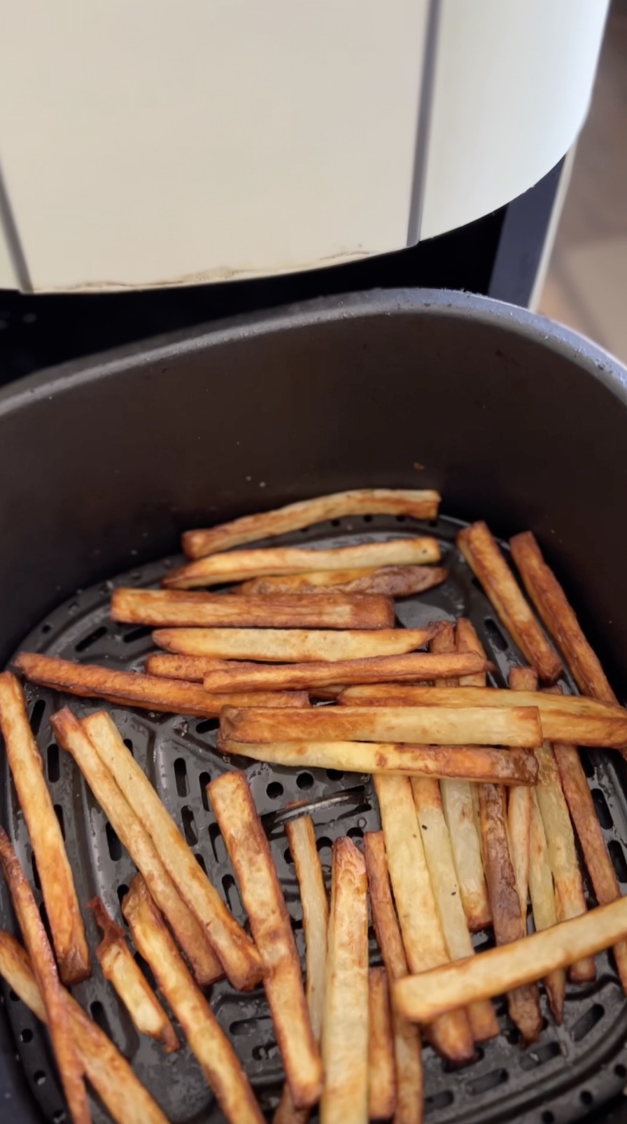 Air fried french fries in air fryer basket.