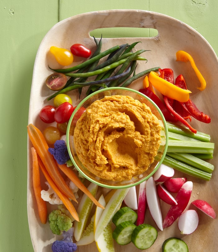Roasted Carrot Hummus surrounded by crunchy veggies for dipping