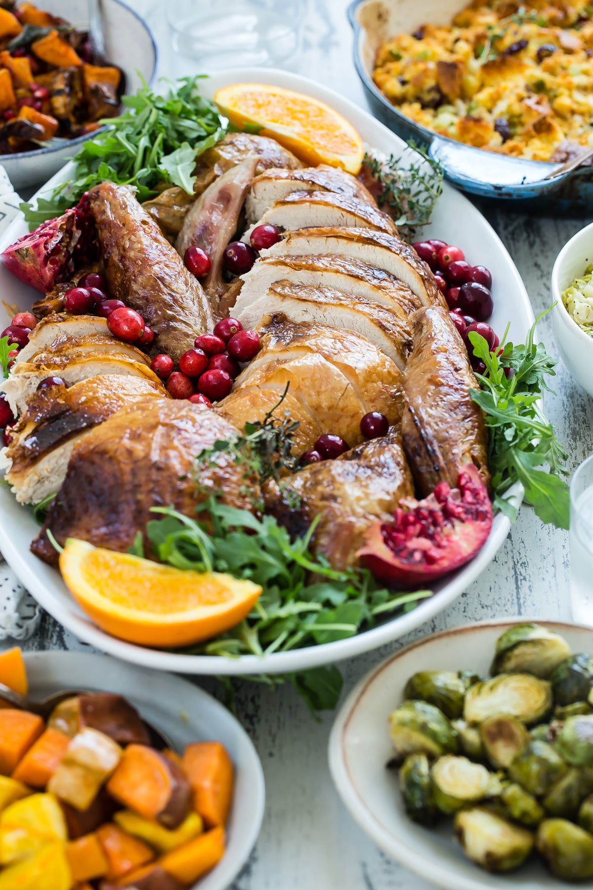 Carved turkey surrounded by Thanksgiving sides.