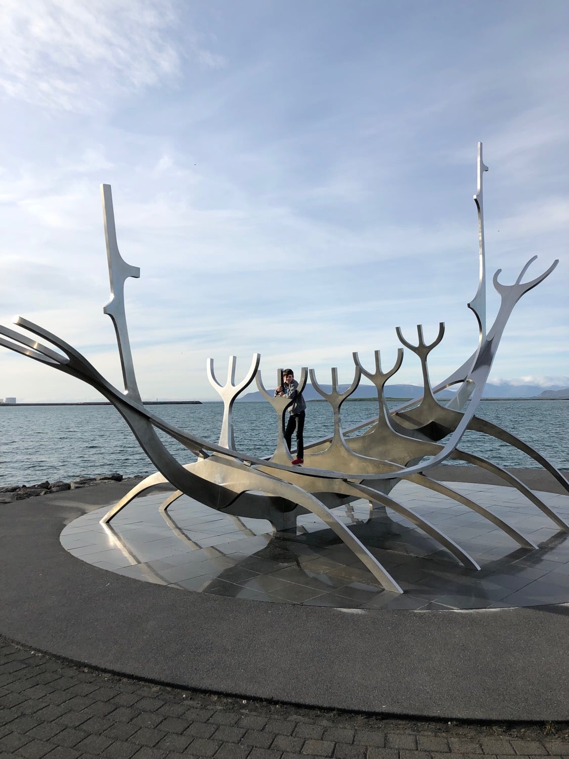 A young boy atop the Sun Voyager statue in Iceland.