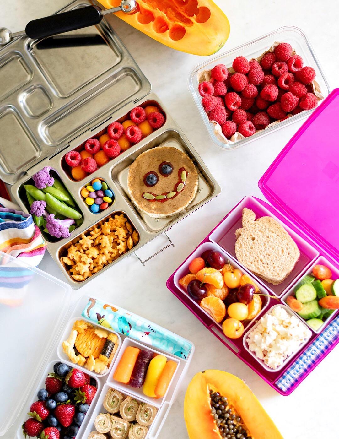 A bento-style lunch boxes filled with school lunches for kids.