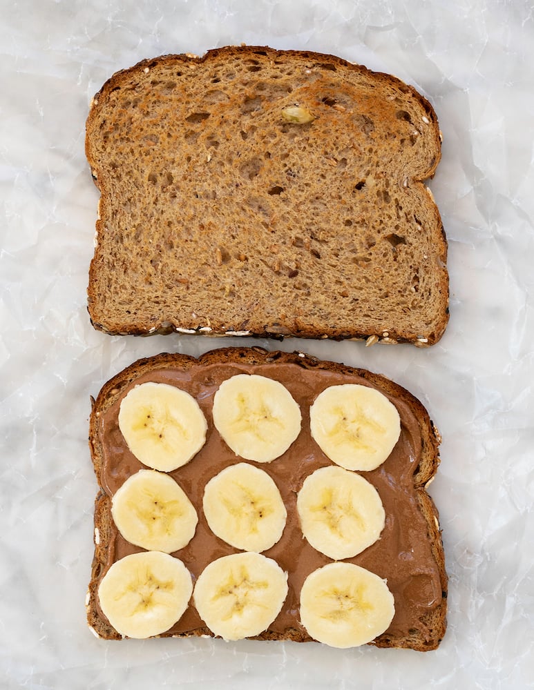 SunButter and banana sandwich on white background.