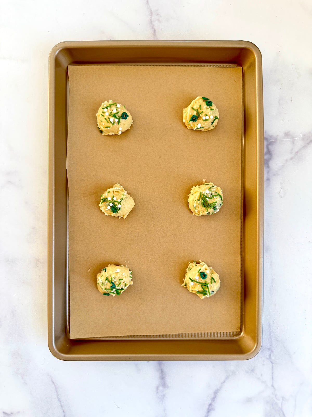 Cake mix sprinkle cookies on a sheet tray ready to bake.