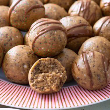 Protein balls drizzled with chocolate on a plate.