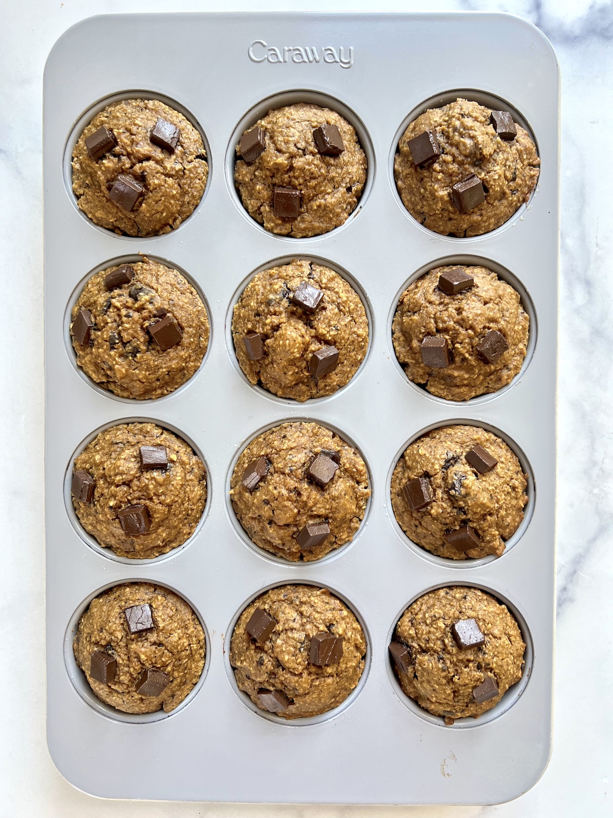 Baked flourless pumpkin chocolate chip muffins in muffin tin.