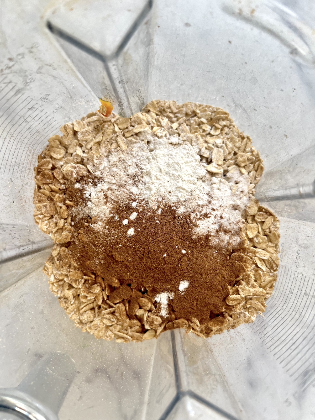 Flourless pumpkin muffins ingredients layered in a blender.