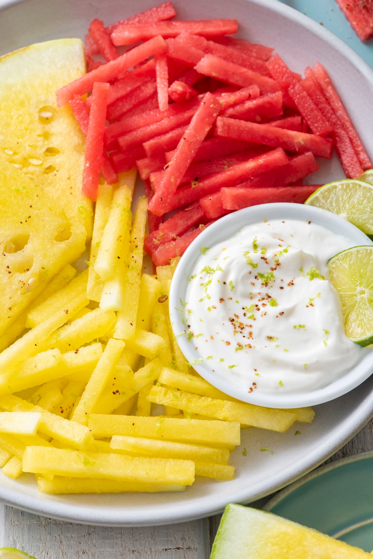 Yellow watermelon and red watermelon cut into sticks served with yogurt dip.