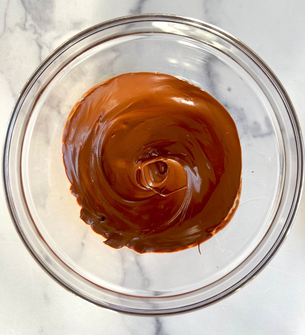 Melted chocolate in glass bowl.