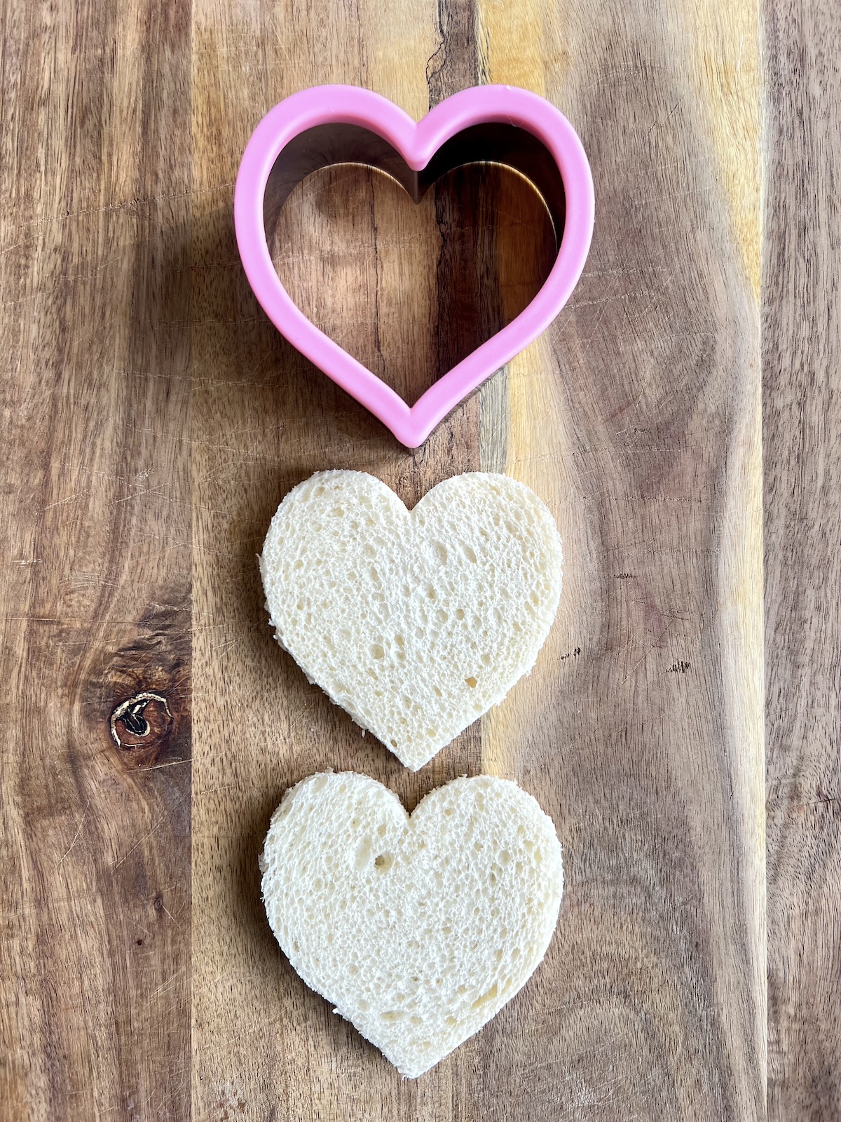 Sandwich bread in the shape of a heart with a heart shaped cookie cutter.
