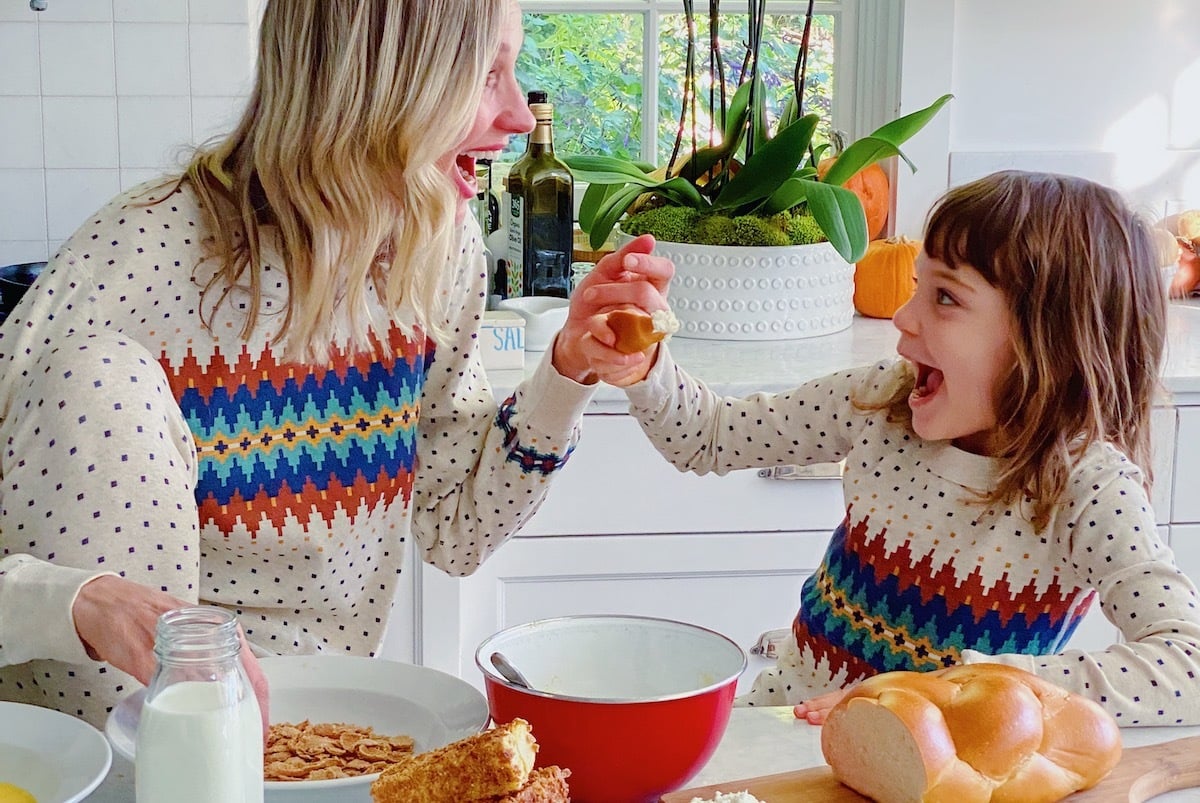 Mother and daughter smiling while eating Christmas brunch together.