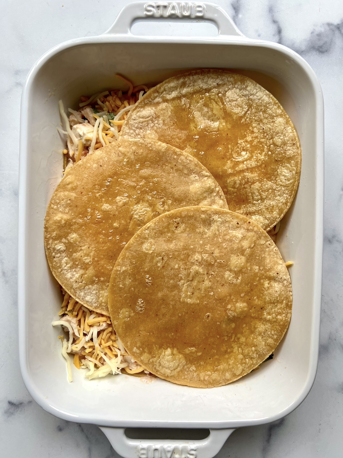 Layered mexican lasagna in baking dish.