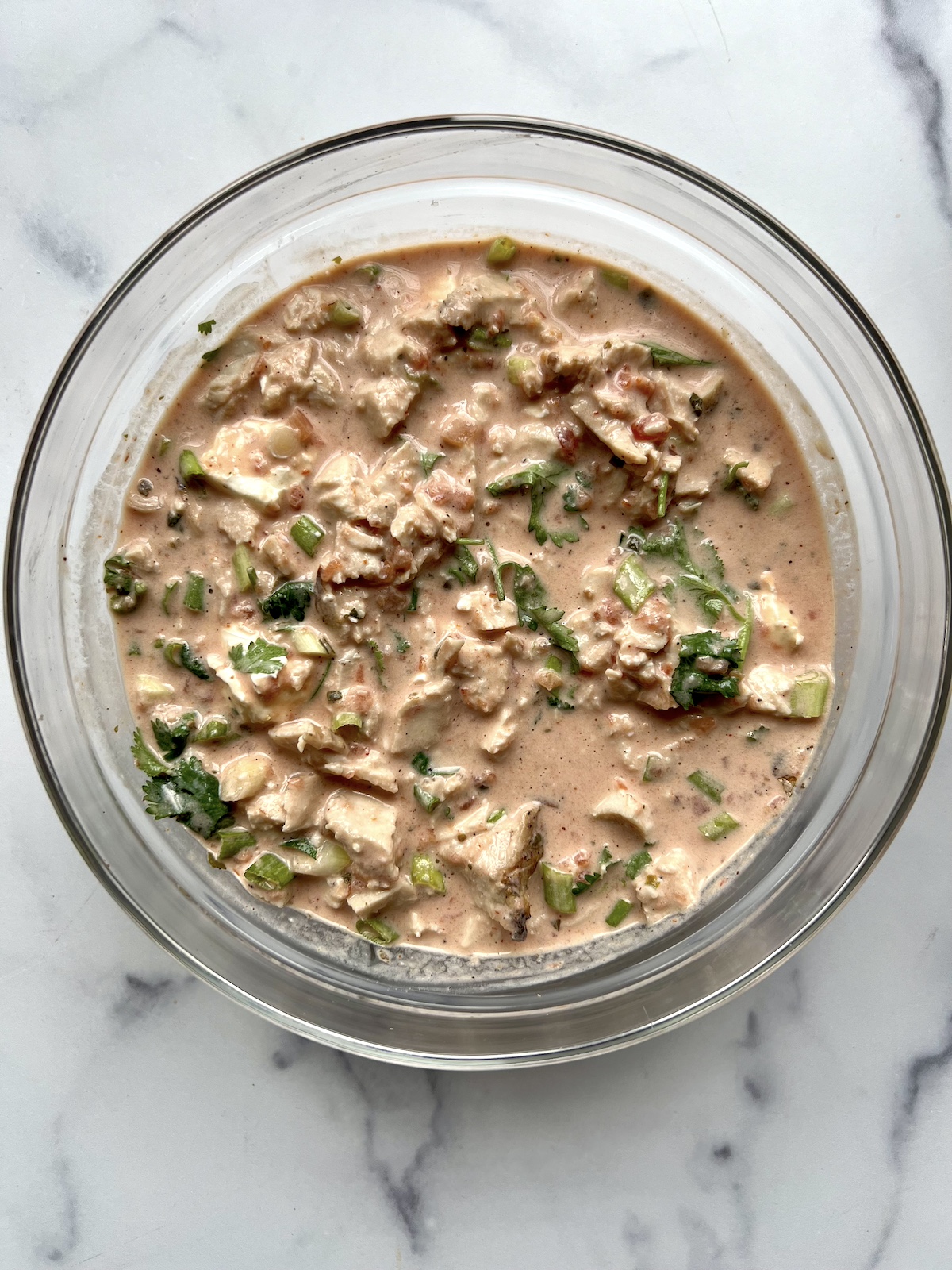 Chicken mixture for Mexican lasagna in a mixing bowl.