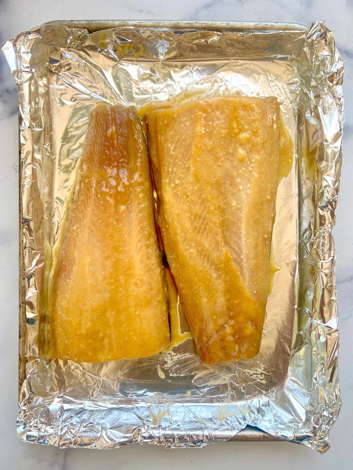 Marinated black cod on foil lined sheet tray.
