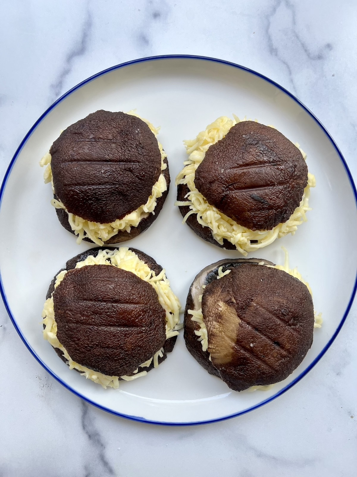 Portobello mushrooms stuffed with cheese on a plate.