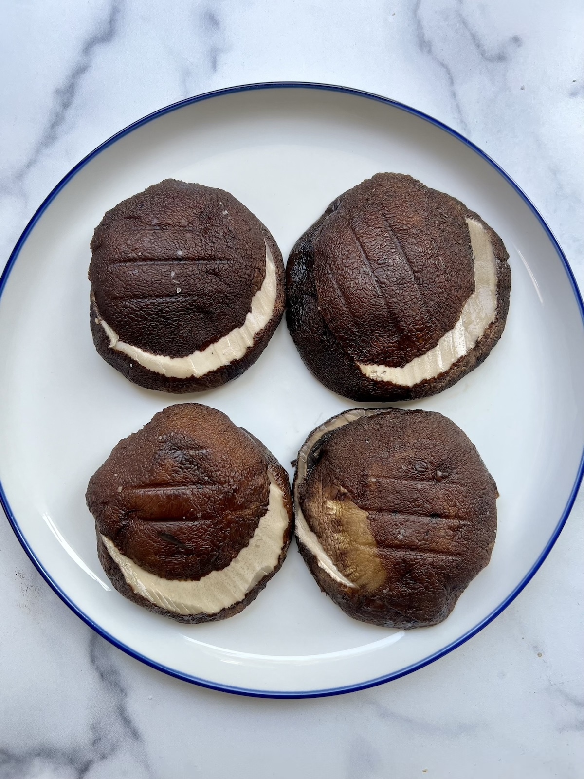 Portobello mushrooms sliced horizontally on a plate.
