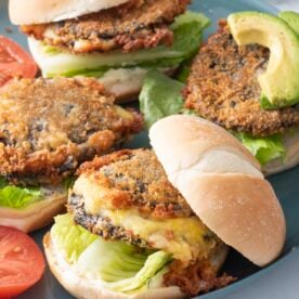 Shroom burgers with toppings on blue plate.