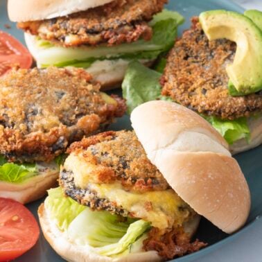 Shroom burgers with toppings on blue plate.