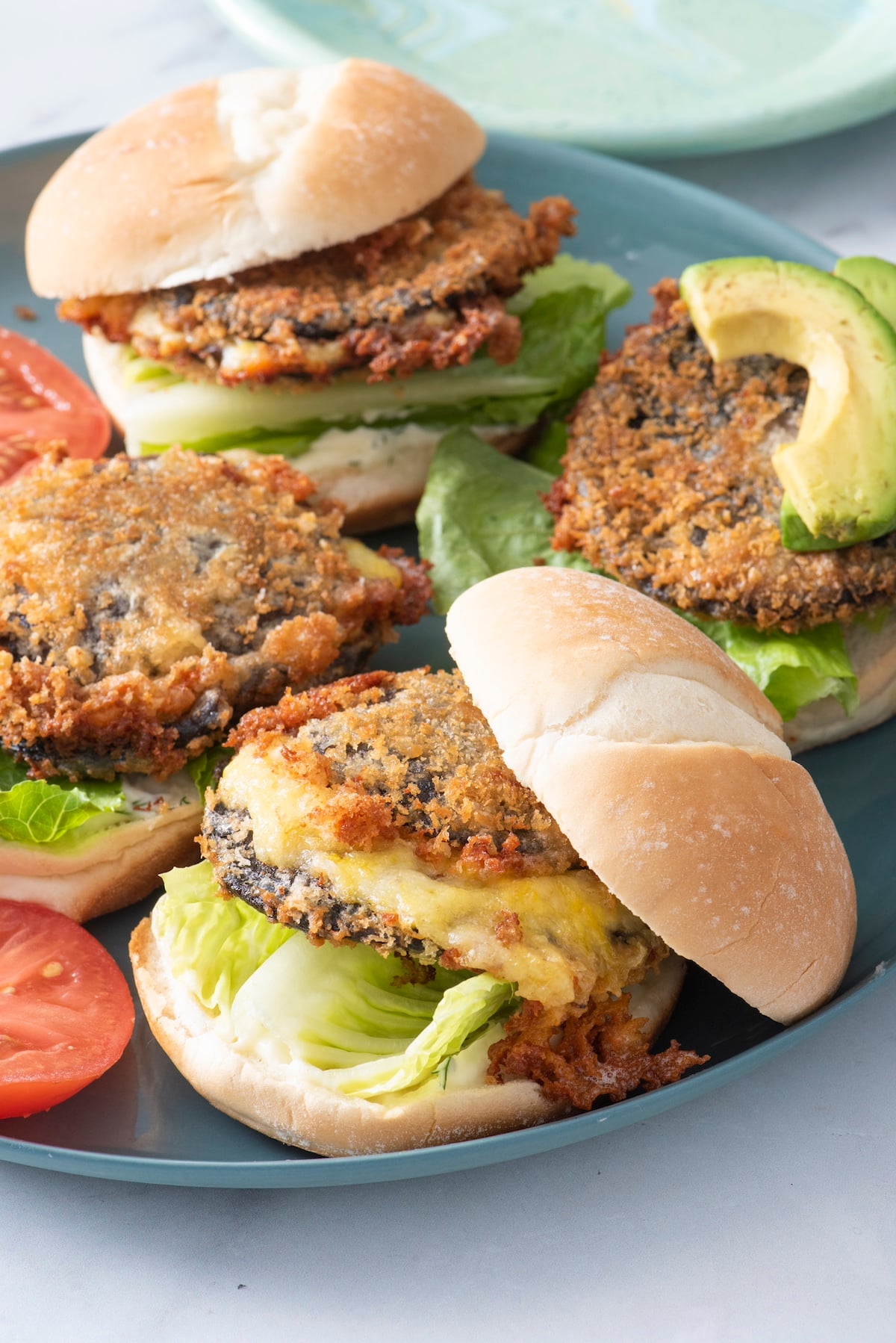 Shroom burgers with toppings on blue plate.