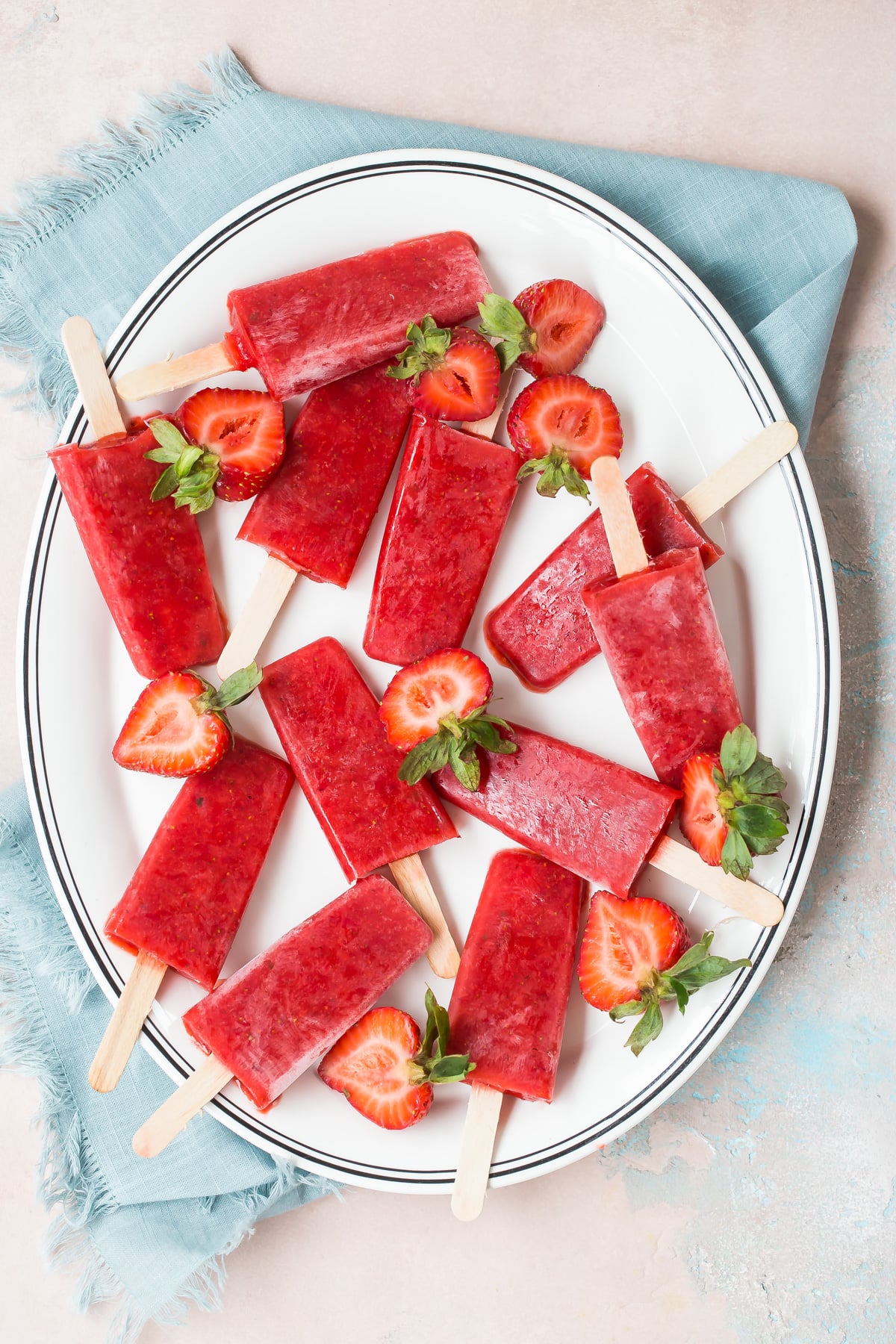 Strawberry popsicles displayed on a plate.