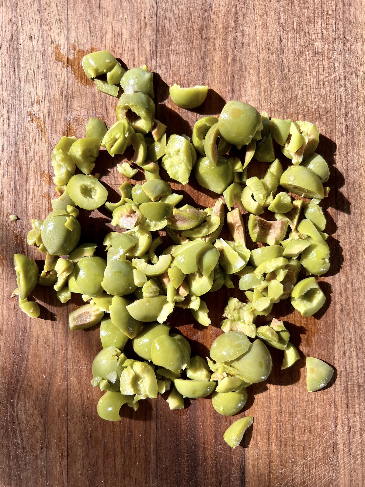 Crushed olives on cutting board.