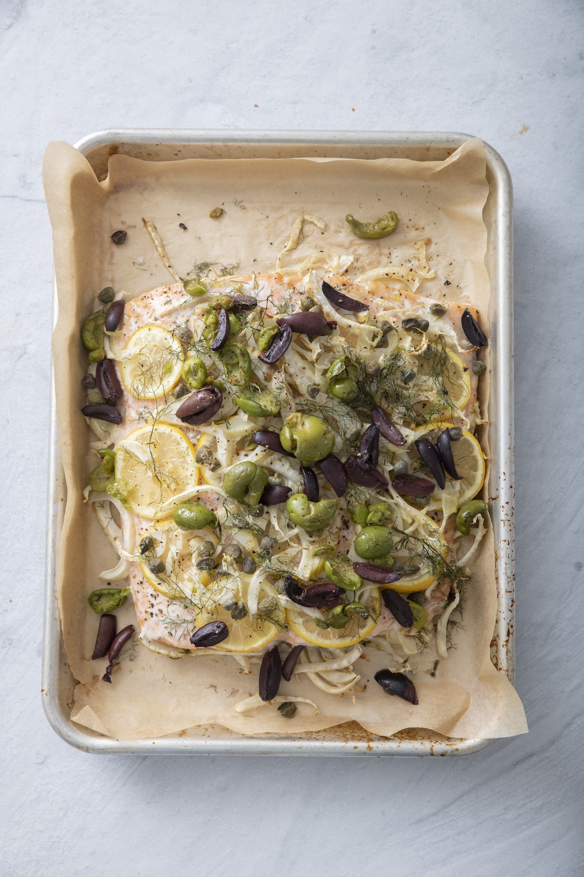 Baked salmon with fennel, lemon slices and olives.