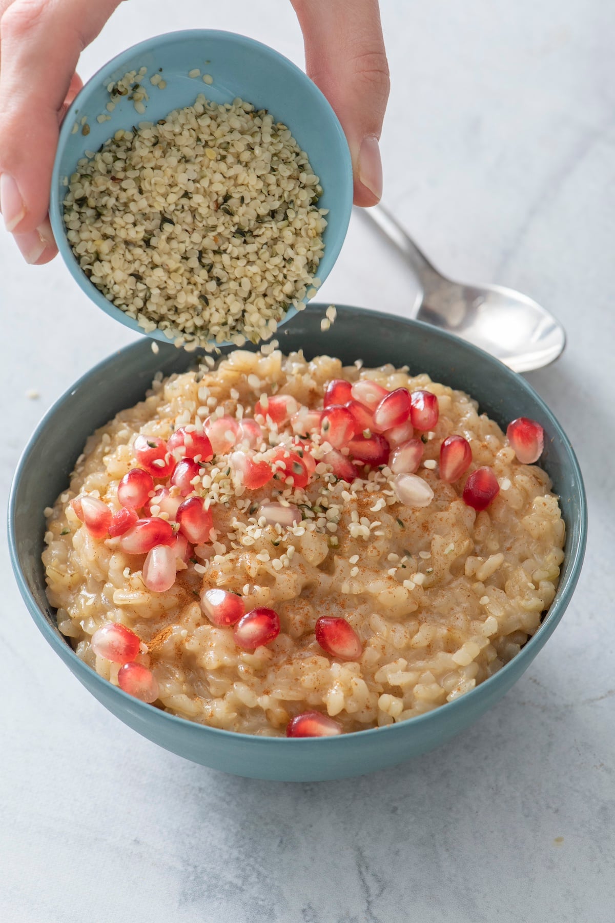 Topping leftover rice pudding with hemp seeds.
