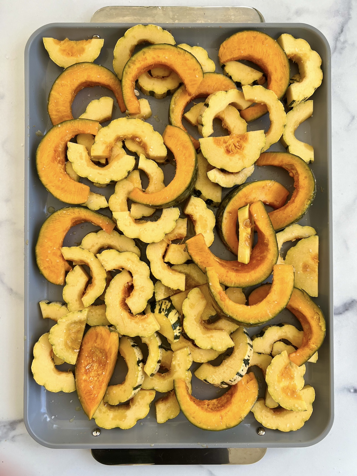 Delicata and kabocha squash on baking sheet.