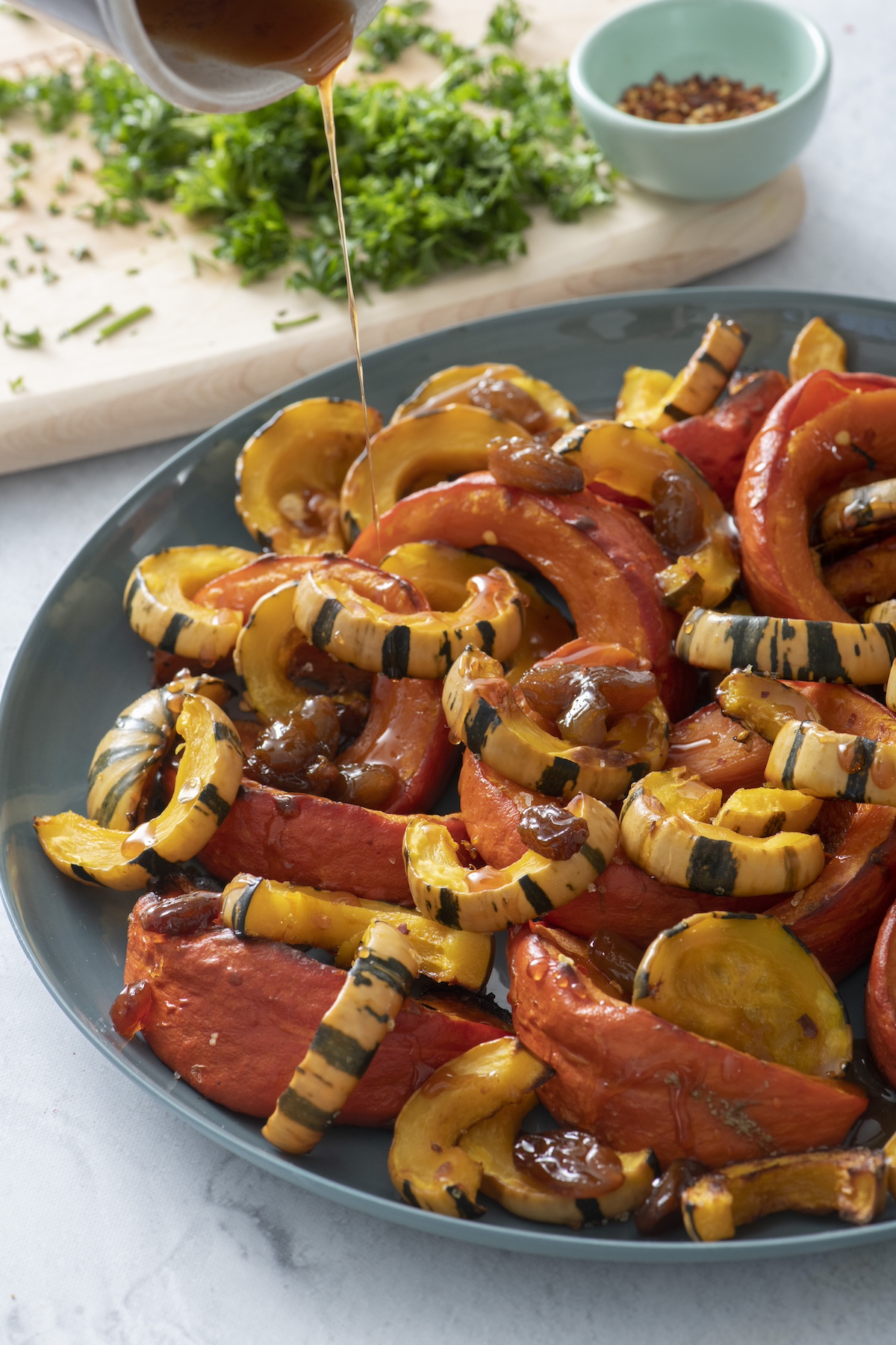 Pouring sweet and sour glaze over roasted squash.