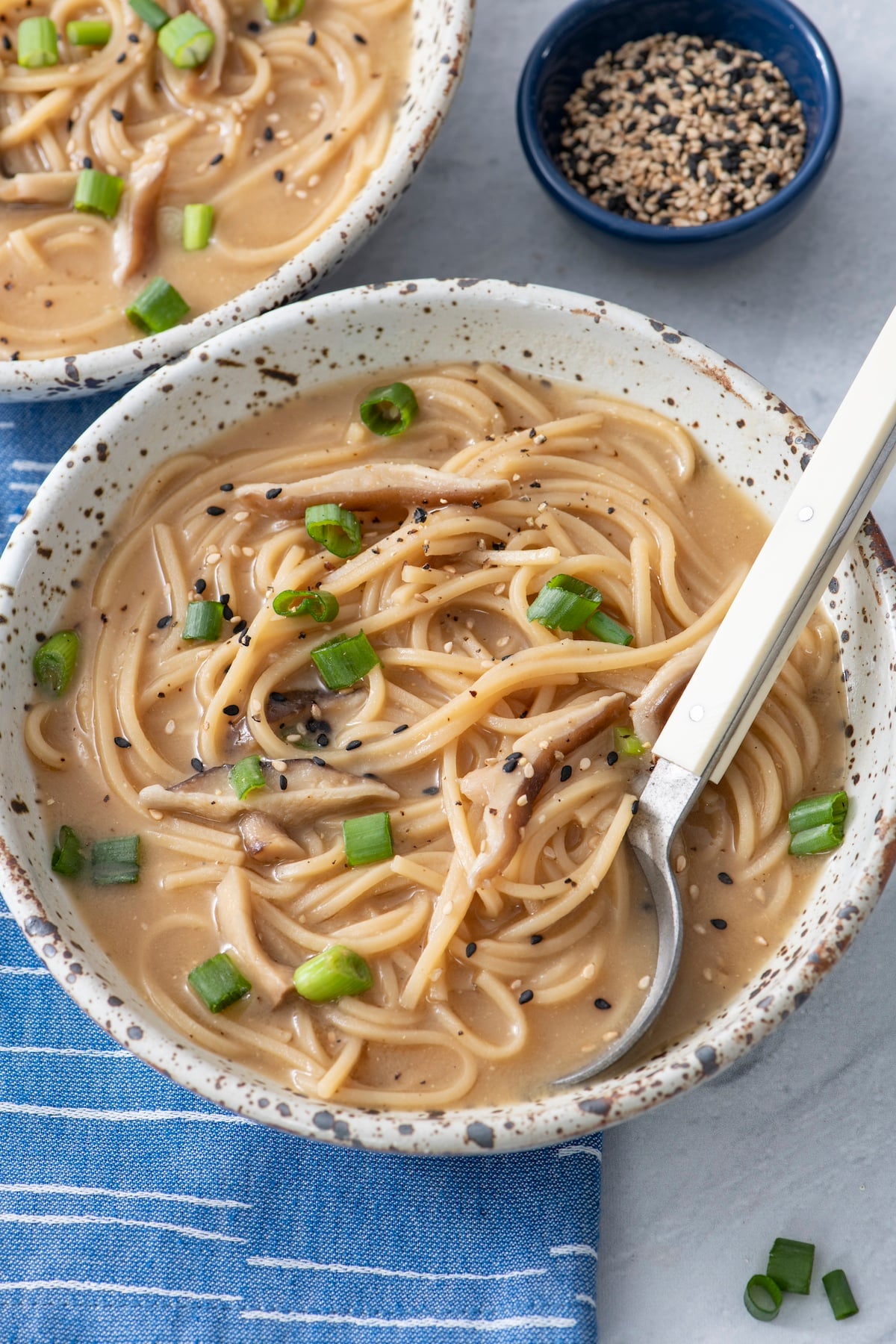 Bowl of ramen noodle soup with spoon.
