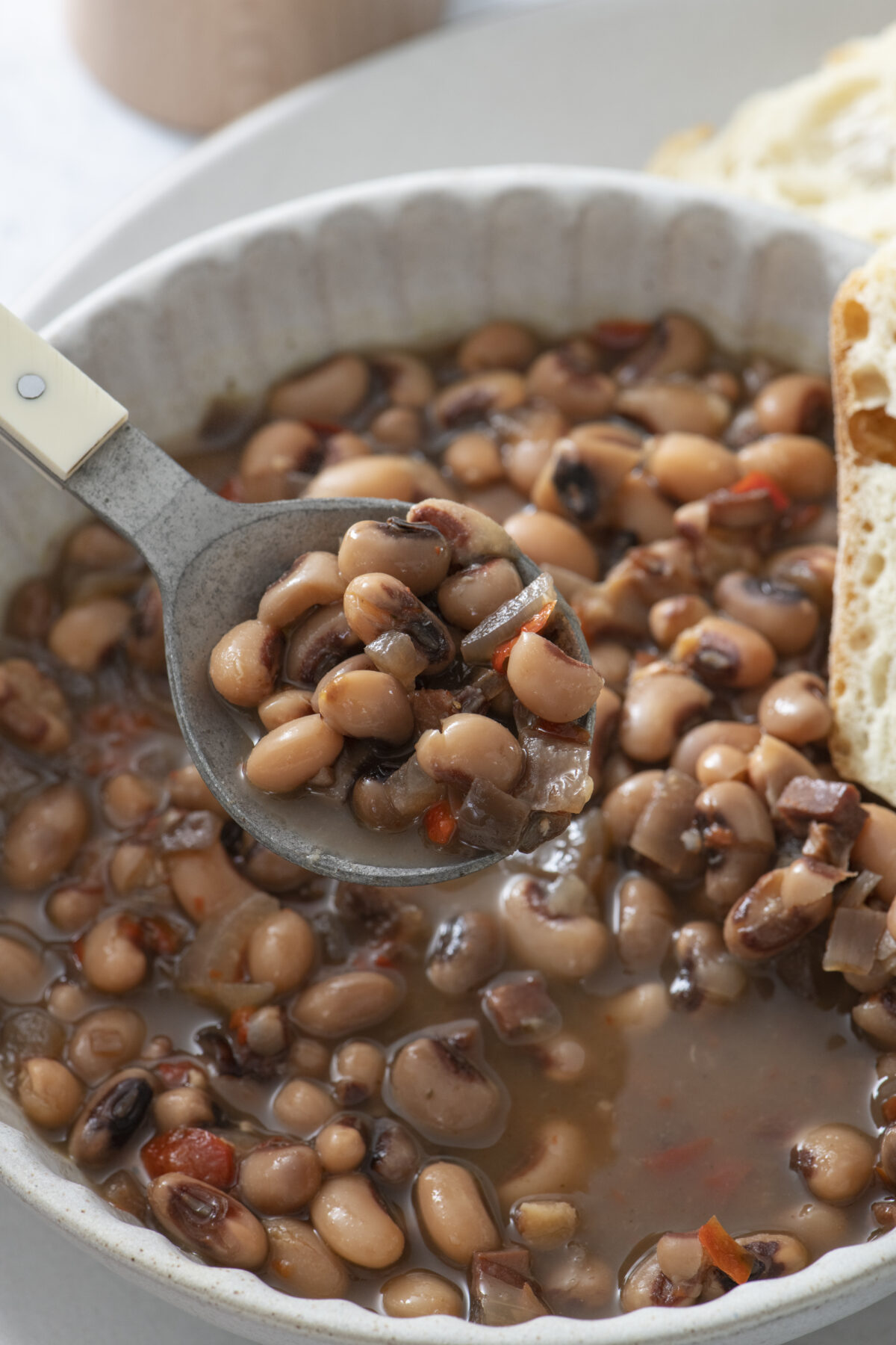 Black eyed peas in a bowl with a spoon.
