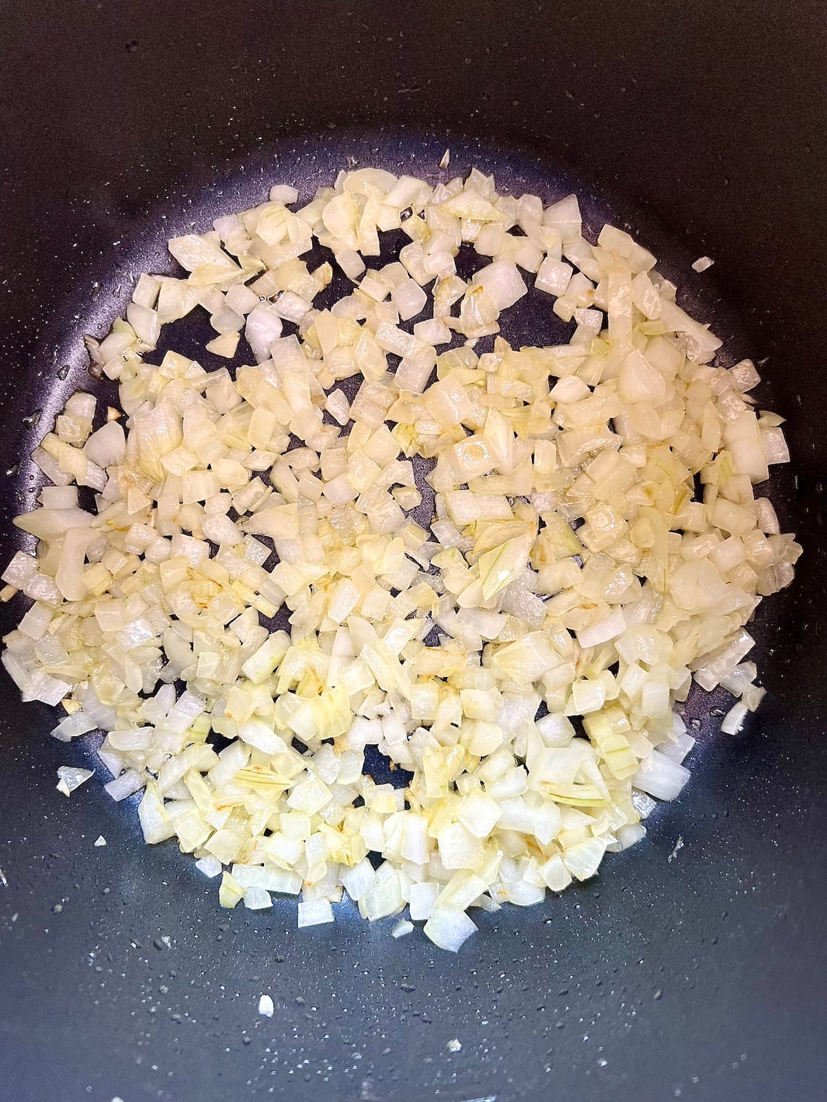 Chopped onions sautéing in pan.